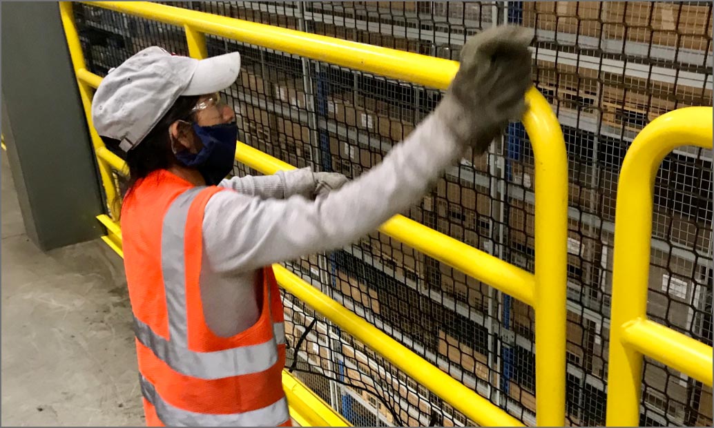 tidy employee sanitizing a handrail